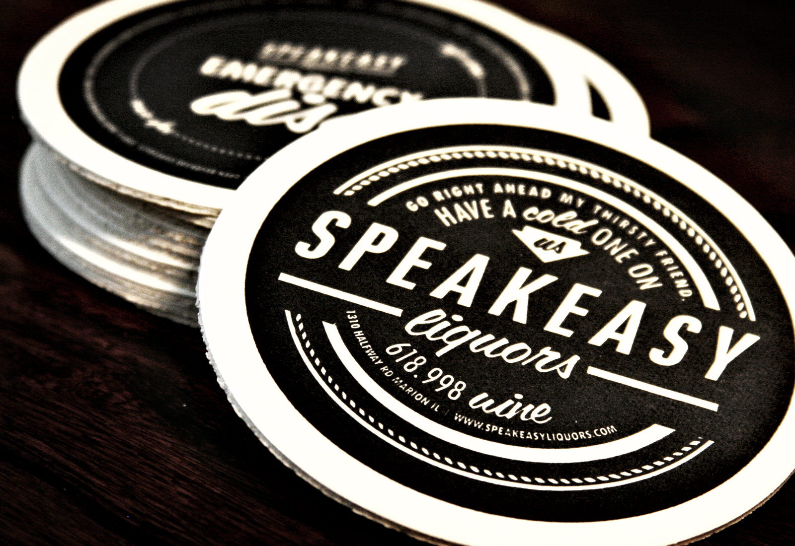 Speakeasy Liquors branded coasters showing retail branding design