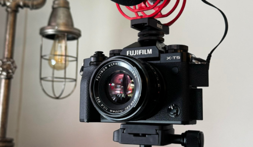Fujifilm xt5 camera with rhode microphone attached to the top and light bulb in the background