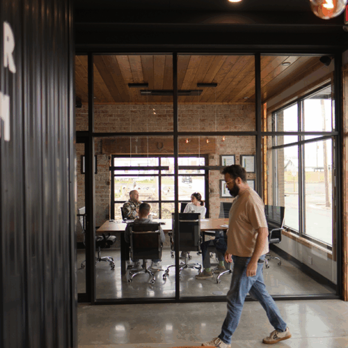 James Arthur branding agency employee walking past a full conference room meeting